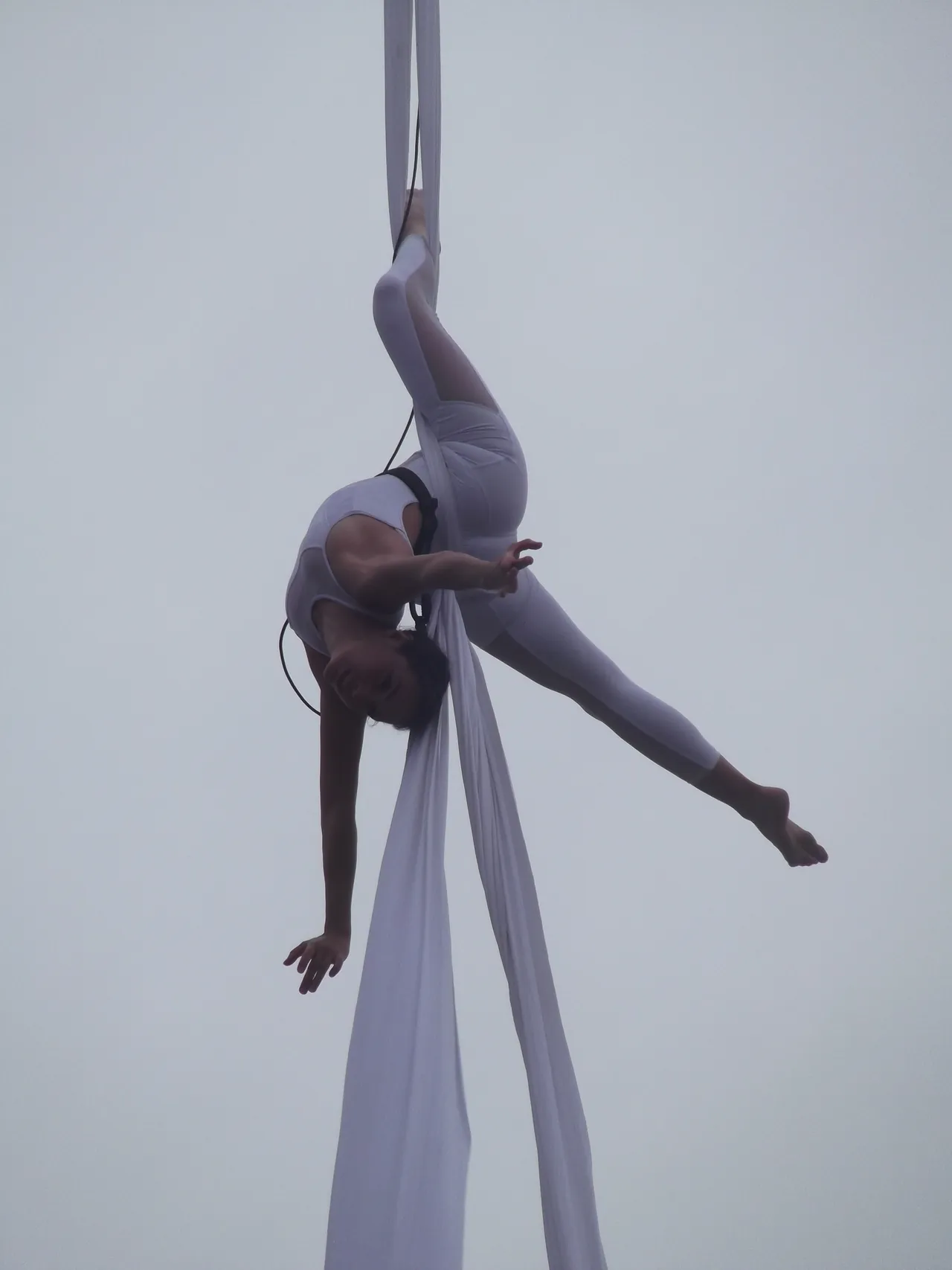 Astrid Halgand la tête en bas dans un tissu aérien, ciel clair