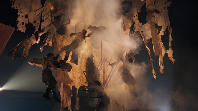 Des interprètes en mouvement sur le décor incliné du spectacle The Rise